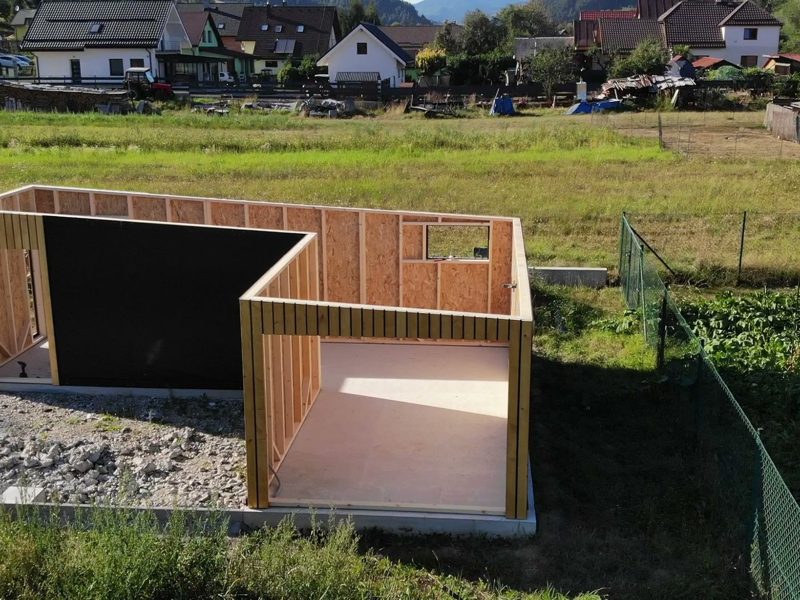 Panely stien prídu z dielne hotové – rám, OSB doska a fólia – a v deň montáže stoja (Jasenica, august 2026)